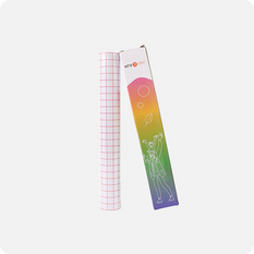 Roll of grid paper next to a colorful packaging box on a white background