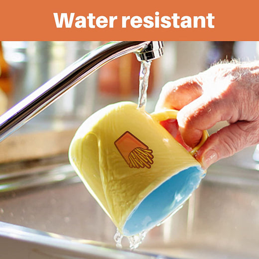 Yellow mug with blue interior being rinsed under running water, labeled 'Water resistant'.
